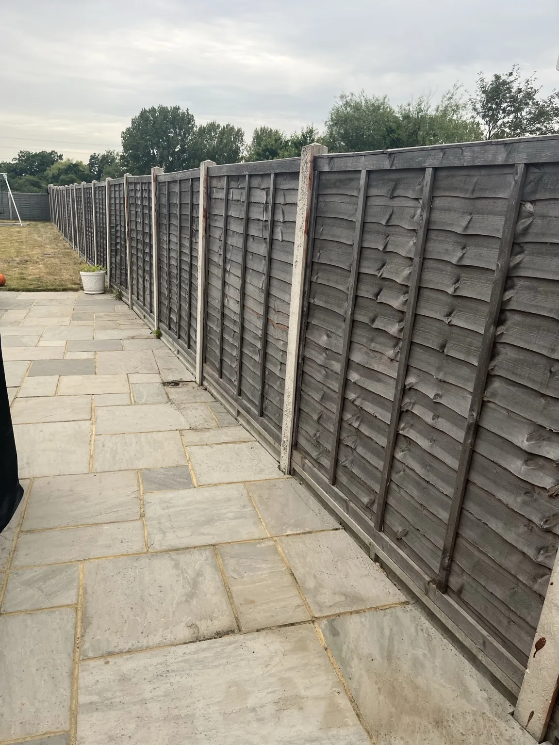 Cleaned paving beside fence